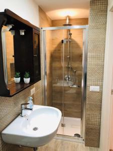 y baño con ducha y lavabo blanco. en Classic Home, en Castelbuono