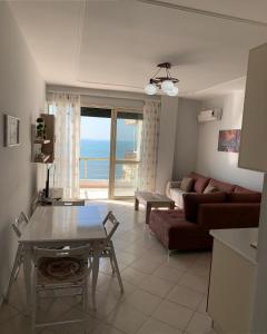 una sala de estar con un sofá y una mesa en The Sunset Apartament, en Durrës