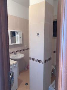 Un pequeño baño con lavabo y lavadora. en The Sunset Apartament, en Durrës