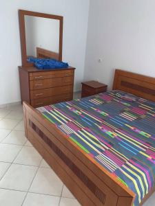 Un dormitorio con una cama con una cómoda y un espejo. en The Sunset Apartament, en Durrës