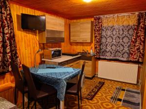 a kitchen with a table with chairs and a microwave at У Оксани in Kvasy