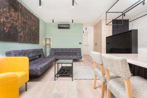 a living room with a couch and a table at City of the Kings-Bijou Apartment in Krakow