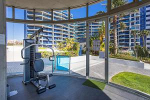 einen Fitnessraum mit Blick auf ein Gebäude in der Unterkunft CH Oasis Sea Senses Punta Prima in Torrevieja
