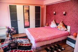 蘭卡的住宿－英格麗旅館，一间卧室配有一张粉红色的床和红色的墙壁