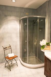 a shower in a bathroom with a chair and a table at Agriturismo La Meridiana in Guidonia
