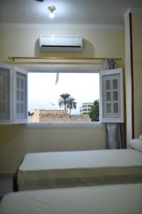 a bedroom with two beds and a window with a view of the beach at Kosh royal house in Aswan