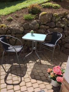 a white table and two chairs on a patio at Ferienwohnung zum Heilbrünnchen in Emmelshausen