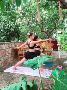 two women doing a yoga pose on a yoga mat at L'onda Oda Bodrum in Bodrum City