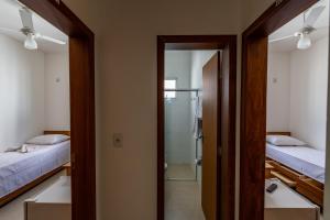 a room with two beds and a mirror at Hospedaria Santo Antônio in Diamantina