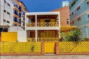 una recinzione gialla di fronte a un edificio di Apart Hotel Vila Mar a Florianópolis