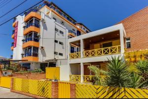 ein Gebäude mit einem gelben Zaun davor in der Unterkunft Apart Hotel Vila Mar in Florianópolis