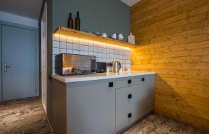 a kitchen with a sink and a wooden wall at New Gudauri Atrium 224 in Gudauri