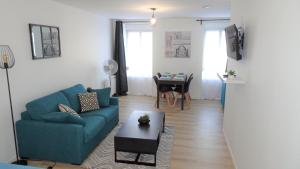 a living room with a blue couch and a table at Appartement cosy proche gare in Vierzon