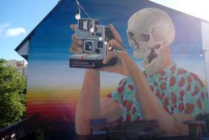 a mural of a person holding a cell phone at Hostel Casagrande in Mar del Plata