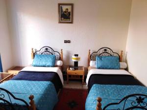 a room with two beds with blue pillows at Hotel Tiout in Taroudant +32 photos