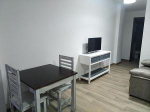 uma sala de estar com uma mesa de jantar e uma televisão em Apartamentos Buena Vista 1 em Coto Rios