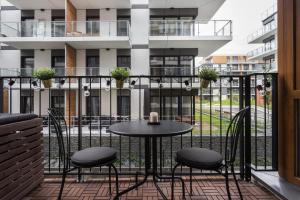 a patio with a table and chairs on a balcony at City of the Kings-Bacalar Apartment in Krakow