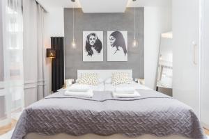 a bedroom with a large bed with four pictures on the wall at City of the Kings-Bacalar Apartment in Krakow
