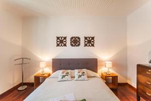 a bedroom with a bed with two night stands and two lamps at Casa da Courela in Nordeste