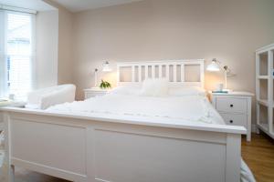 Biała sypialnia z dużym białym łóżkiem i biurkiem w obiekcie 1 Lisburne House w Aberystwyth