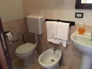 a bathroom with a toilet and a sink with towels at Il Biancospino in Casteggio