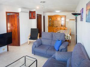 トレ・デル・マールにあるApartamento Marañonのリビングルーム(青いソファ、テレビ付)