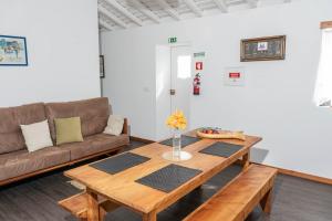 a living room with a couch and a table at Casa Medronho in São Mateus