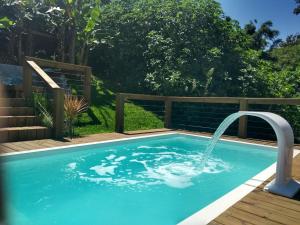 a swimming pool with a water fountain at Pousada Makani, no centrinho do Rosa in Praia do Rosa
