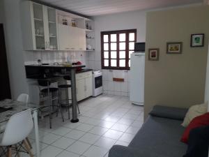 a kitchen with white cabinets and a table in it at Apartamento Stela Maris Praia e Aeroporto in Salvador