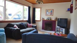 a living room with two couches and a fireplace at Centabay Lodge and Backpackers in Paihia