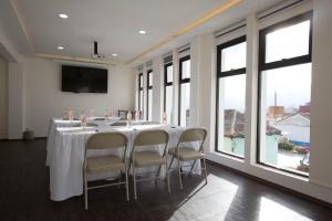 a conference room with a long table with chairs and windows at Hotel Lunada in Comitán de Domínguez