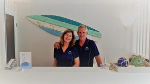 Ein Mann und eine Frau stehen in einem Zimmer mit einem Boot an der Wand. in der Unterkunft Surfers Chalet in Gold Coast