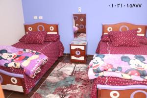 a bedroom with two beds with hello kitty sheets at Amir flat -ميامي- عائلات فقط in Alexandria