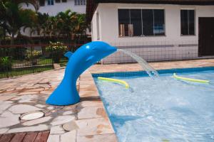a blue dolphin water fountain in a swimming pool at Angra TOP2 Praia Piscina Marina 2 quartos in Angra dos Reis