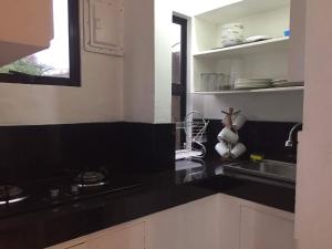 a kitchen with a black counter top and a sink at NVH2 Coron Palawan in Coron
