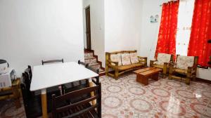 a living room with chairs and a table and red curtains at NVH2 Coron Palawan in Coron