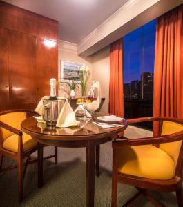 a dining room with a table and chairs and a window at Hotel Park Suites in Lima