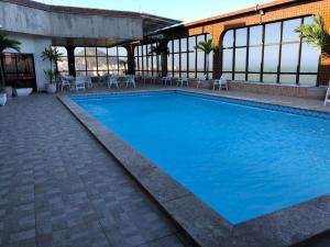 a large blue swimming pool in a building at PRAIA da COSTA ED PASSARGADA in Vila Velha