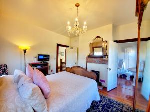 a bedroom with a bed and a fireplace and a mirror at Captain's Inn at Moss Landing in Moss Landing