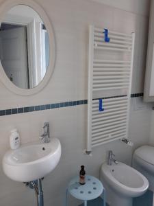 ein Badezimmer mit einem Waschbecken, einem Spiegel und einem WC in der Unterkunft Lupo Azzurro in Siena