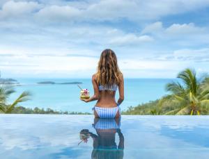 a woman in a bikini standing in the water at a pool at PRIVATE POOL VILLA I Sea Views - Pool - Privacy & Joy in Chaweng