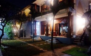 a house with palm trees in front of it at night at The Brick Canggu in Canggu