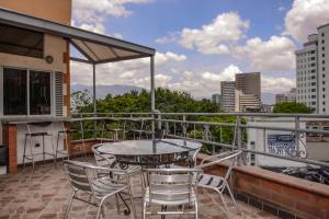 patio con mesa y sillas en el balcón en Calle 10 Suites, en Medellín