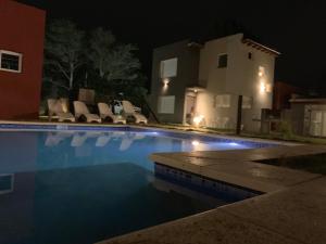 a swimming pool in front of a house at night at Solar de las Gaviotas in Las Gaviotas