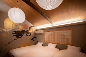 a bedroom with two beds and two chandaliers and lights at Contexted in Osaka