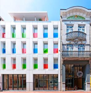 eine Fassade eines Gebäudes mit bunten Fenstern in der Unterkunft Hotel Pantheon Palace by WP Hotels in Blankenberge