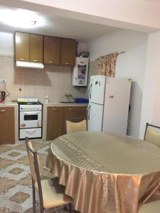 a kitchen with a table and a white refrigerator at Departamento Libertad in San Salvador de Jujuy