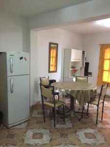 cocina con mesa, sillas y nevera en Departamento Libertad en San Salvador de Jujuy