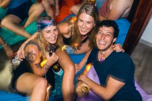 a group of people sitting on beds at a party at Hostel First Mirissa in Mirissa