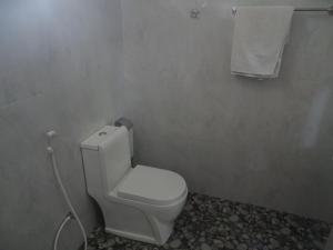 a bathroom with a white toilet and a towel at Sigiriya Camellia Home Stay in Sigiriya